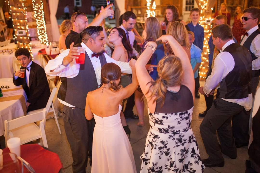 Students dancing in a school event with a DJ.